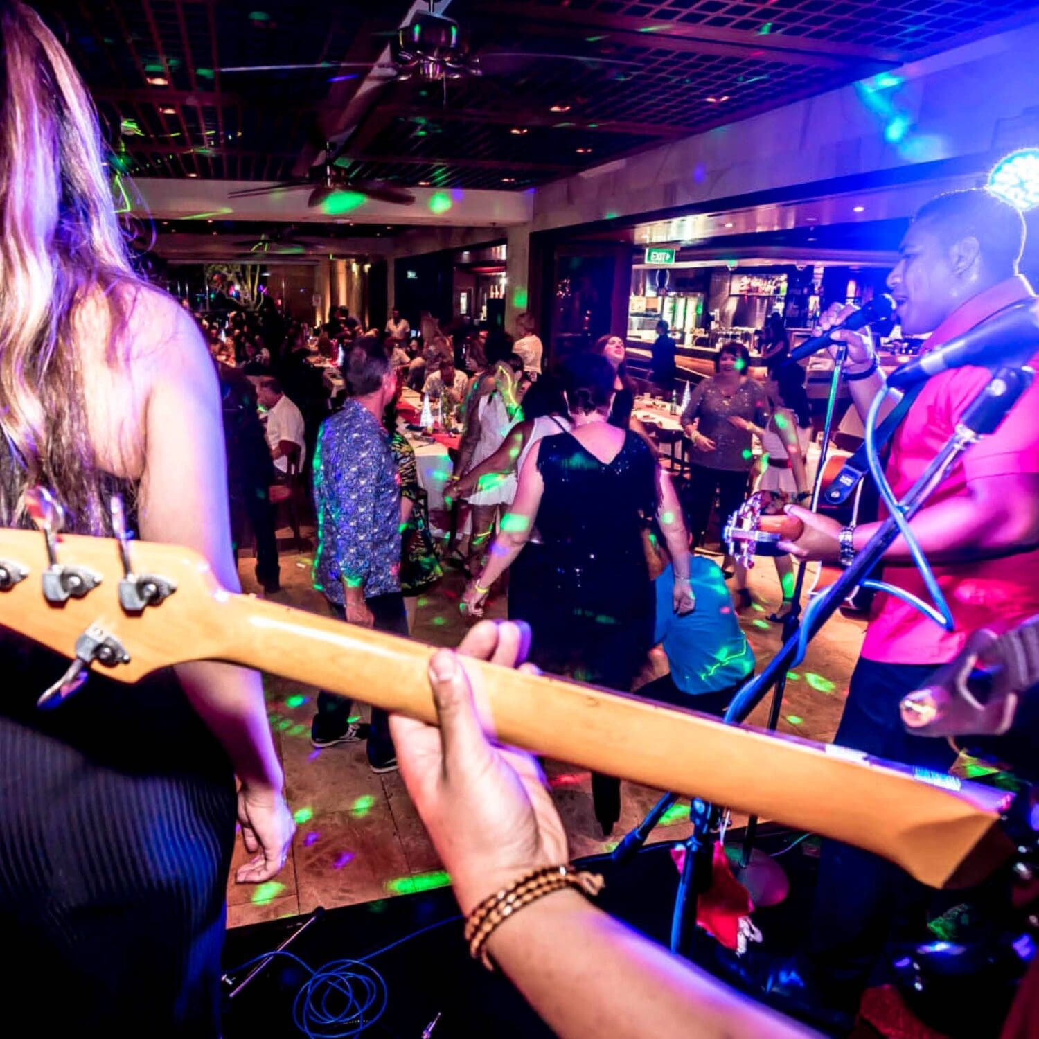 People dancing in the background to a live band;