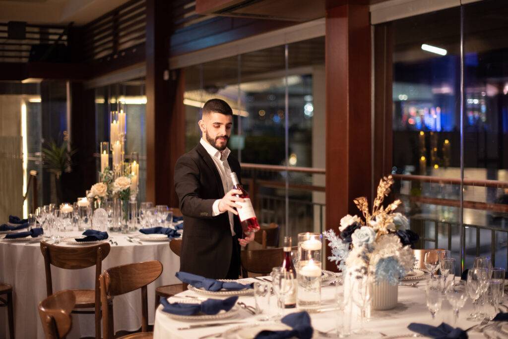 Function staff placing a wine bottle on the table