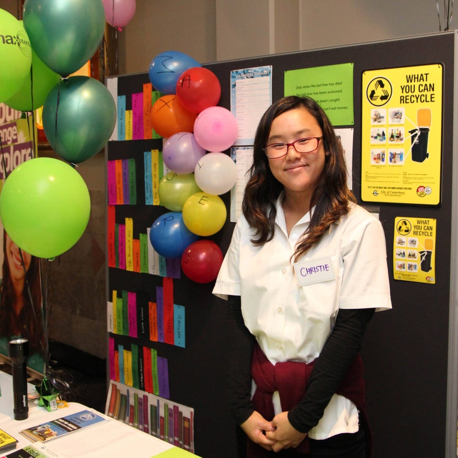 Student posing in front of her school project