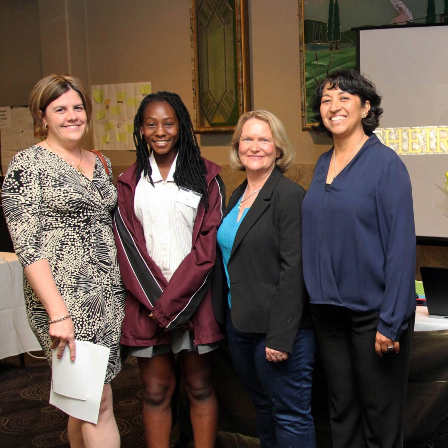 Students standing with her teachers at school presentation