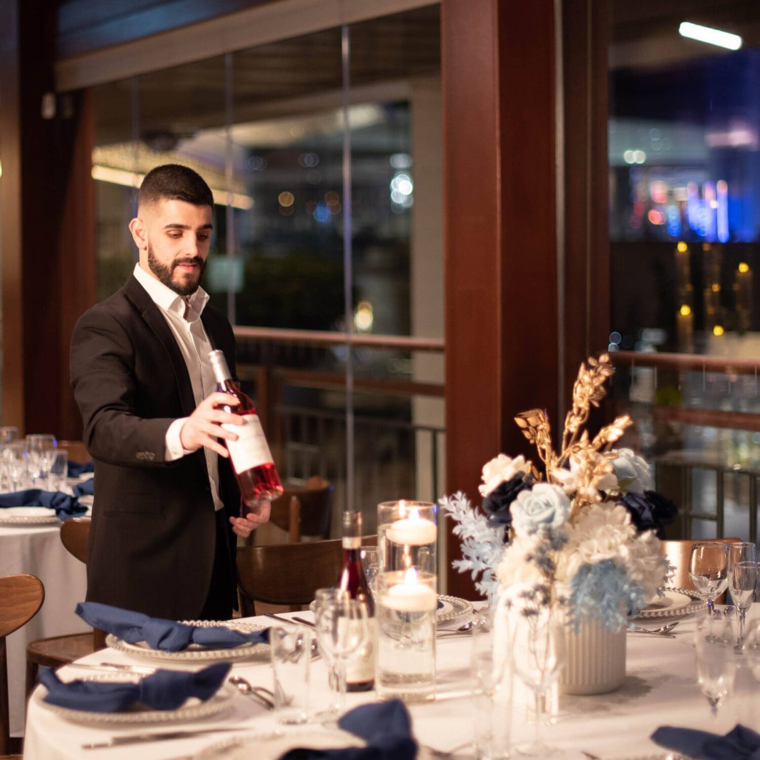 Function staff placing a wine bottle on the table